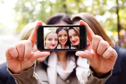 A group of women taking a selfie on a mobile phone.